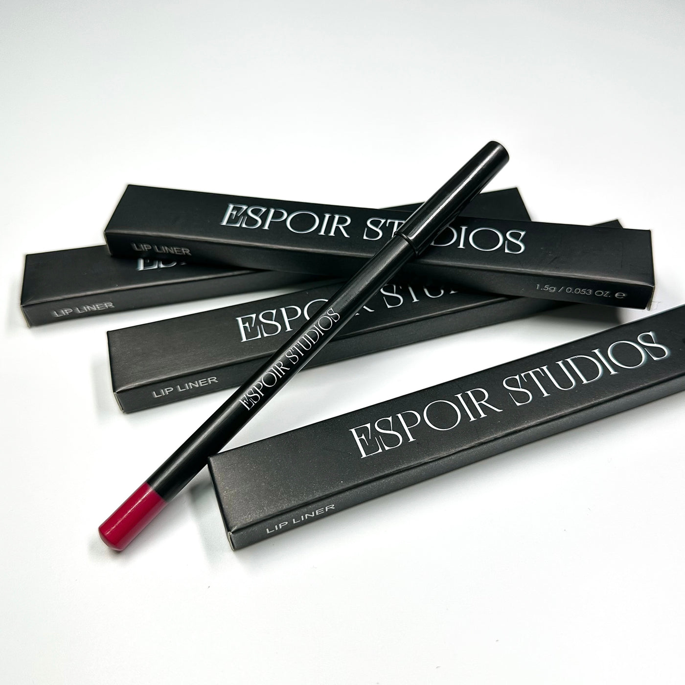 Several black boxes labeled "Espoir Studios" are arranged on a white surface, with one RED LIP LINER PREDRAW PENCIL positioned on top, promising smooth application for precise lip mapping.