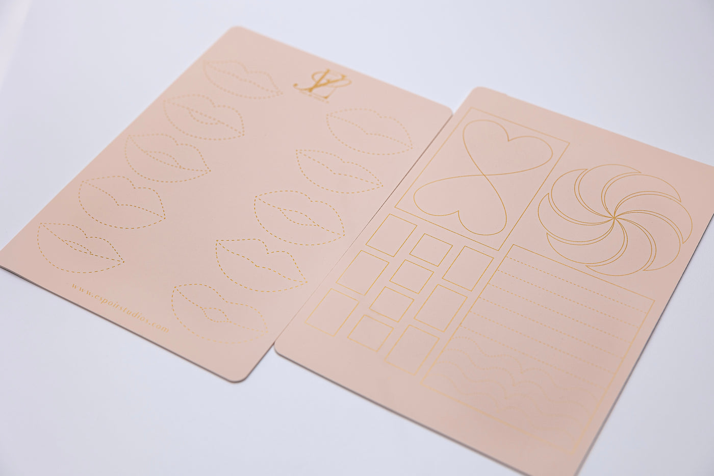 Two peach-colored LIP PRACTICE PADS EXCLUSIVELY MADE BY ESPOIR STUDIOS with various makeup stencil designs, including lips, hearts, spirals, squares, and lines, placed on a white surface by Espoir Studios.